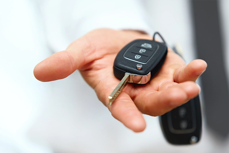 close up image of an open hand handing over their car key
